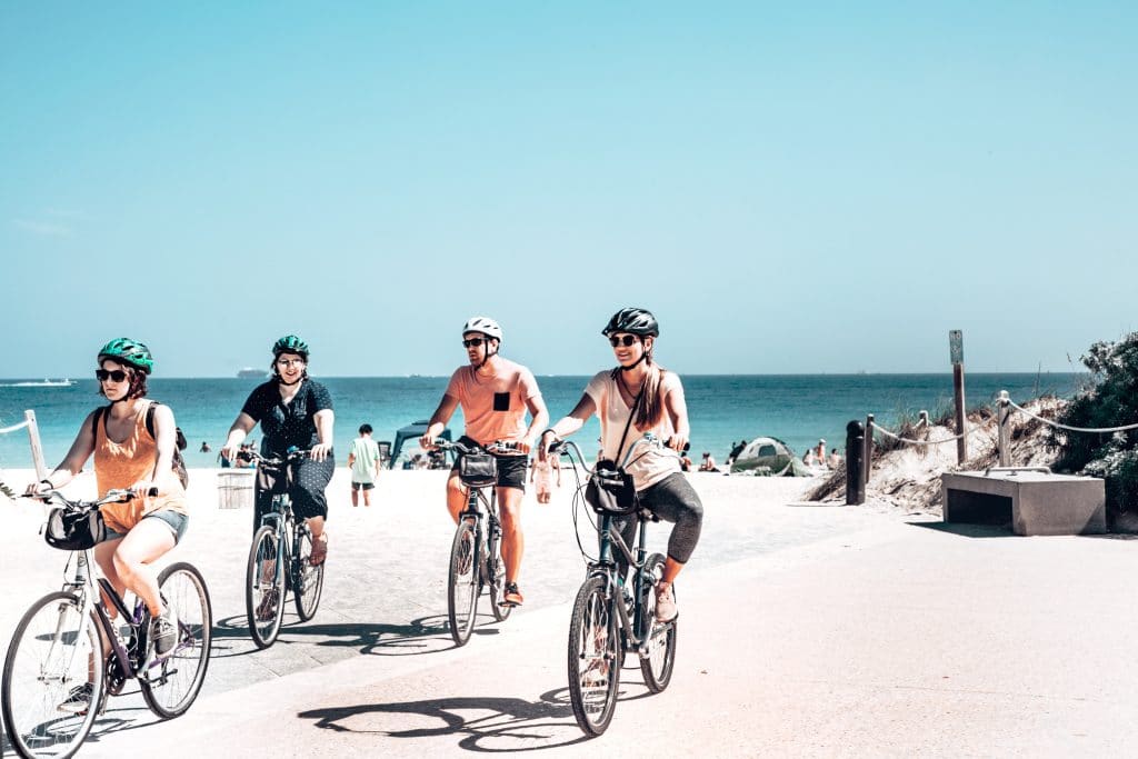 cyclists with helmets riding on the beach
